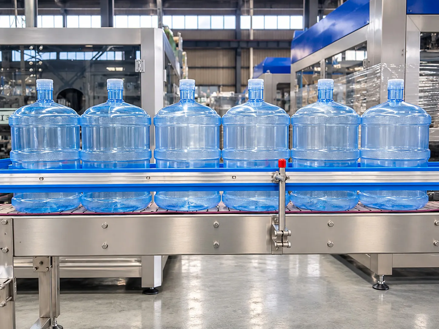 Stainless steel conveyor carrying 5 gallon water barrels